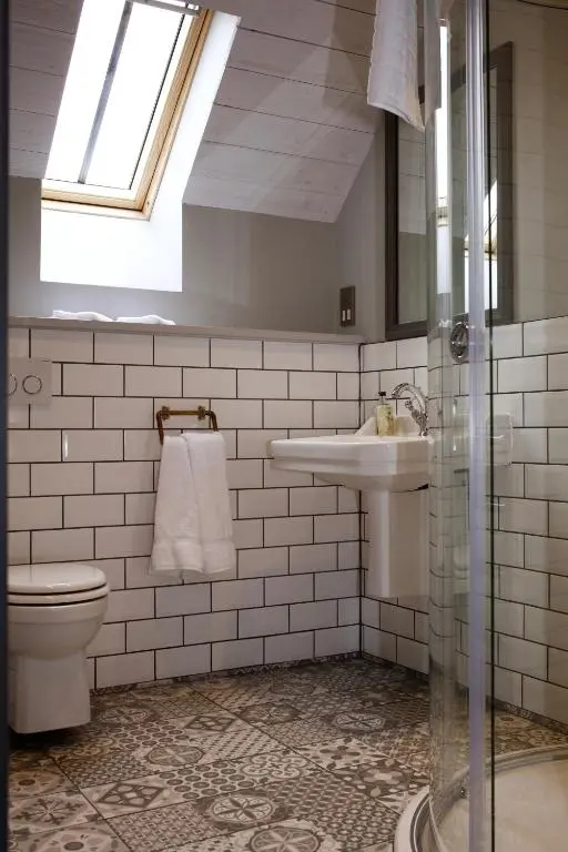 a bathroom with a toilet and a sink and a window at The Lodges @ Barra Castle in Inverurie