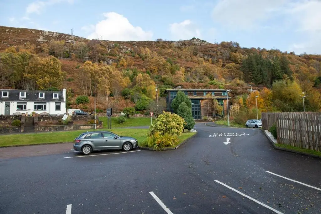 a car parked in a parking lot in front of a mountain at Harbour House in Ullapool