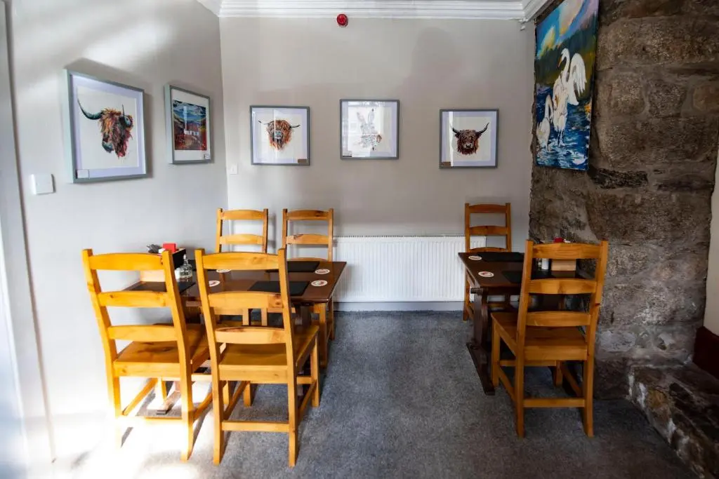 a dining room with a table and chairs at The Kirkmichael Hotel in Kirkmichael
