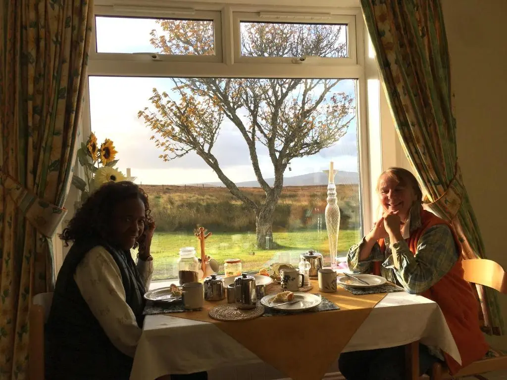 two women sitting at a table in front of a window at Garvault House in Kinbrace