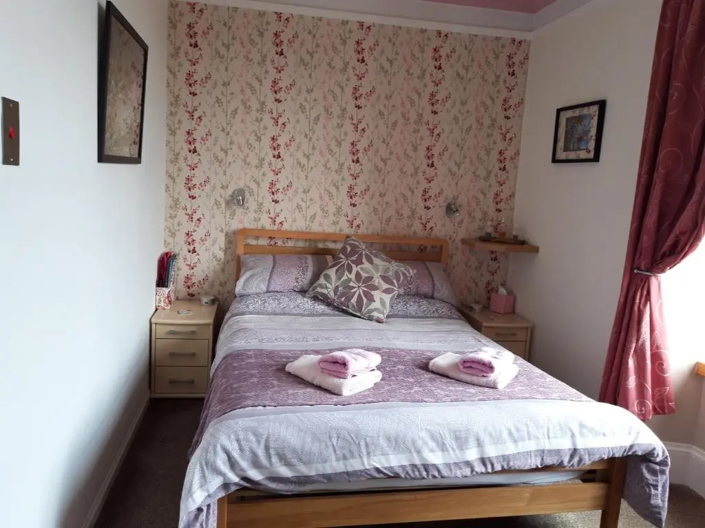 a bedroom with a bed with two towels on it at Gowanbrae in Dufftown