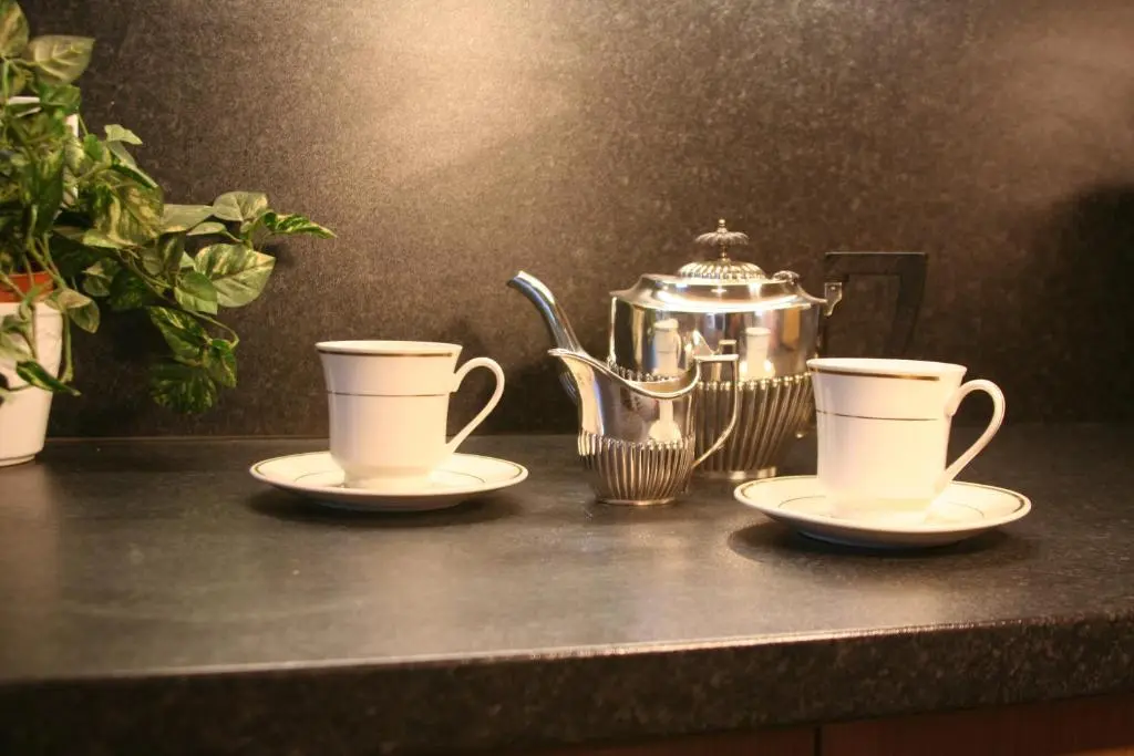 two tea cups and a tea kettle on a counter at Mulberry in Nairn