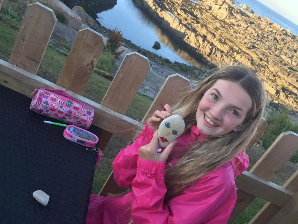 a young girl is holding a stuffed animal at Door to the Shore - Seafront Cottages in Sandhaven