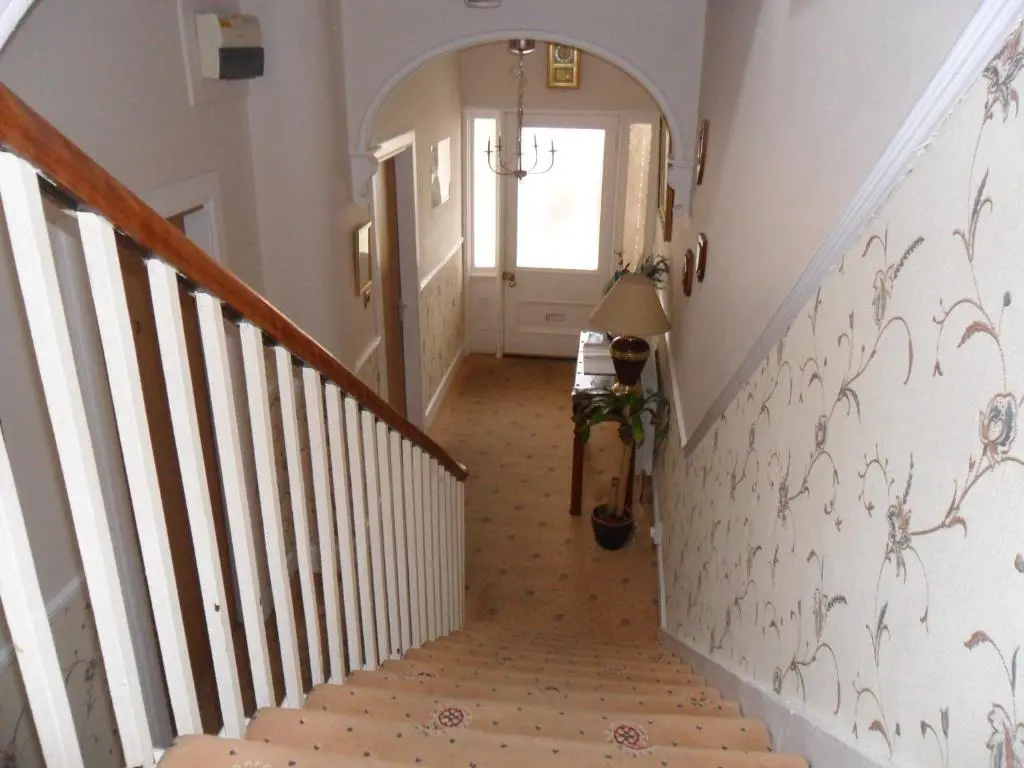 a hallway with a stairway leading up to a door at Armadale Guest House in Inverness