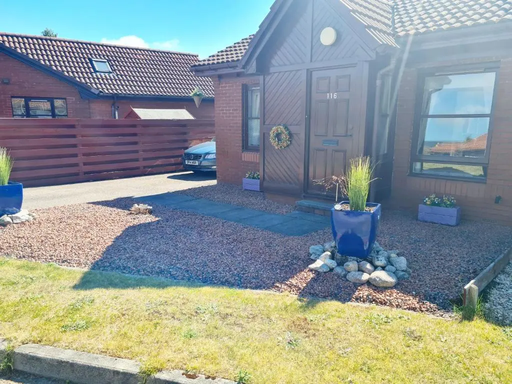 a yard with a house with a fence at Aviemore Stay & Explore in Aviemore