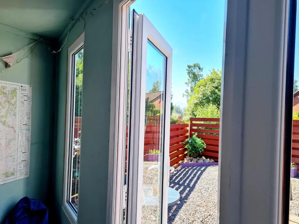 an open door to a yard with a fence at Aviemore Stay & Explore in Aviemore