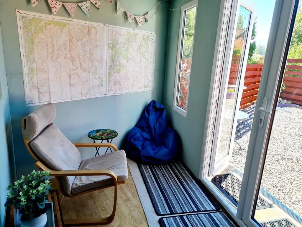 a room with a chair and a map on the wall at Aviemore Stay & Explore in Aviemore