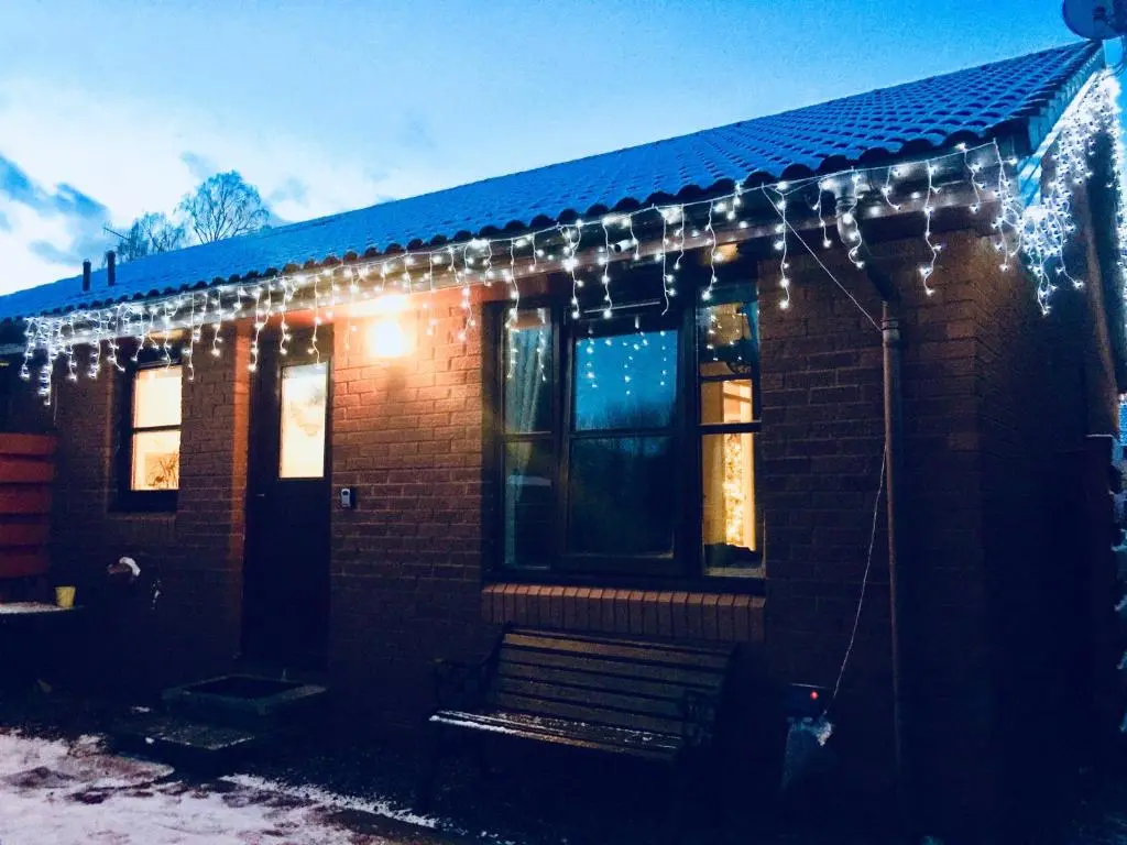 a brick house with christmas lights on it at Aviemore Stay & Explore in Aviemore