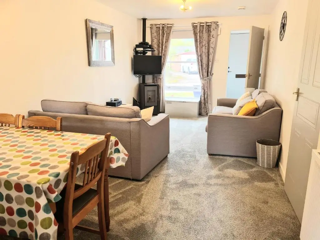 a living room with two couches and a table at Aviemore Stay & Explore in Aviemore