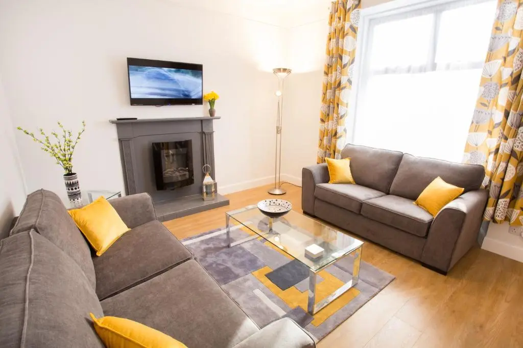 a living room with a couch and a fireplace at Crown Apartment in Inverness