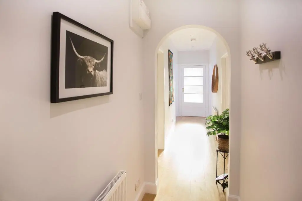 a hallway with a picture of a deer on the wall at Crown Apartment in Inverness