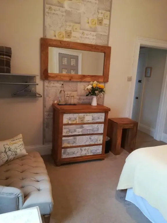 a bedroom with a dresser and a mirror at Furain in Peterculter