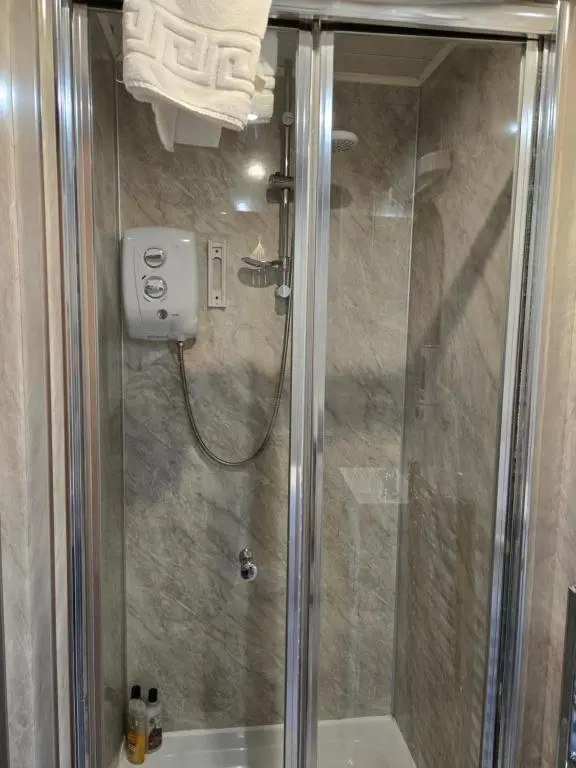 a shower with a glass door in a bathroom at Ivanhoe Guest House in Inverness