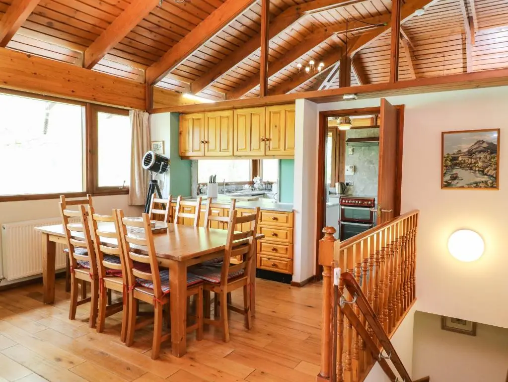 a kitchen and dining room with a wooden table and chairs at Katchana in Insh
