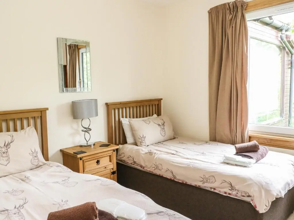 a bedroom with two beds and a window at Katchana in Insh