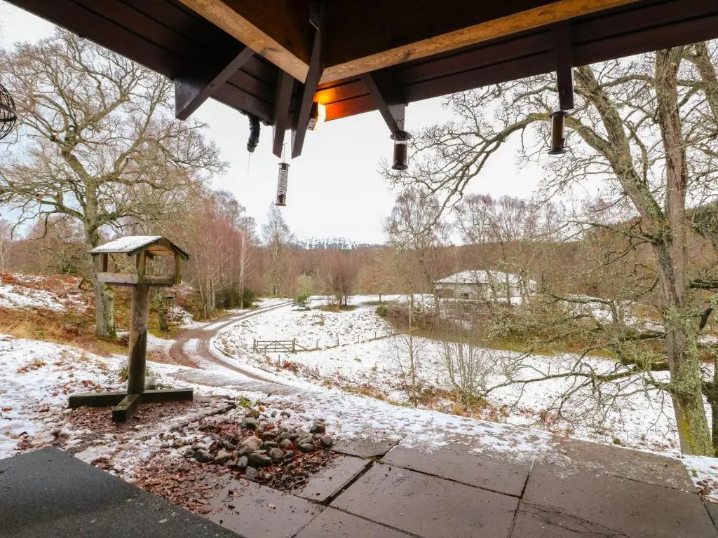 a bird house sitting on a snow covered path at Katchana in Insh