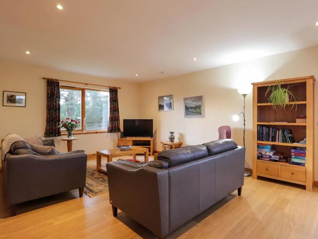 a living room with two couches and a television at Bruach Gorm Cottage in Grantown on Spey