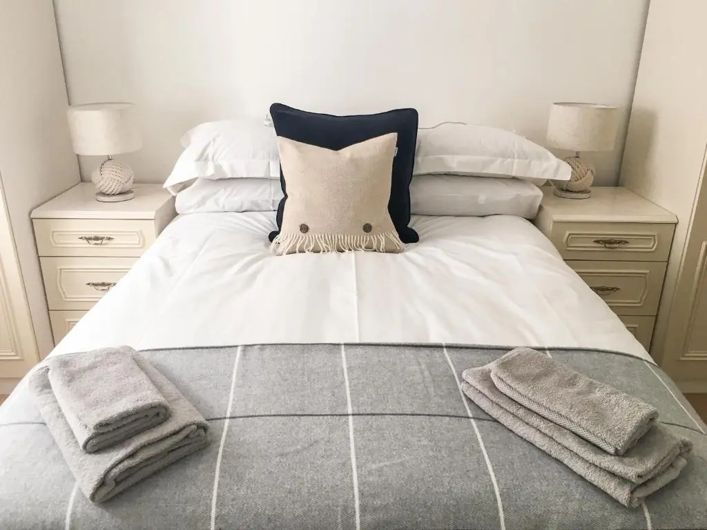 a bed with two pillows and towels on it at 85 Seatown in Cullen