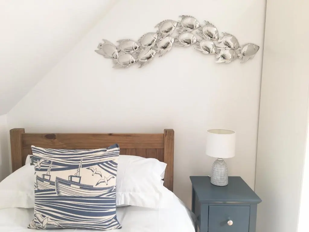 a bedroom with a bed with a chandelier on the wall at 85 Seatown in Cullen