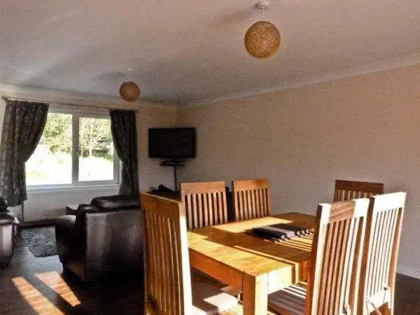a dining room with a wooden table and chairs at Braewood in Invermoriston