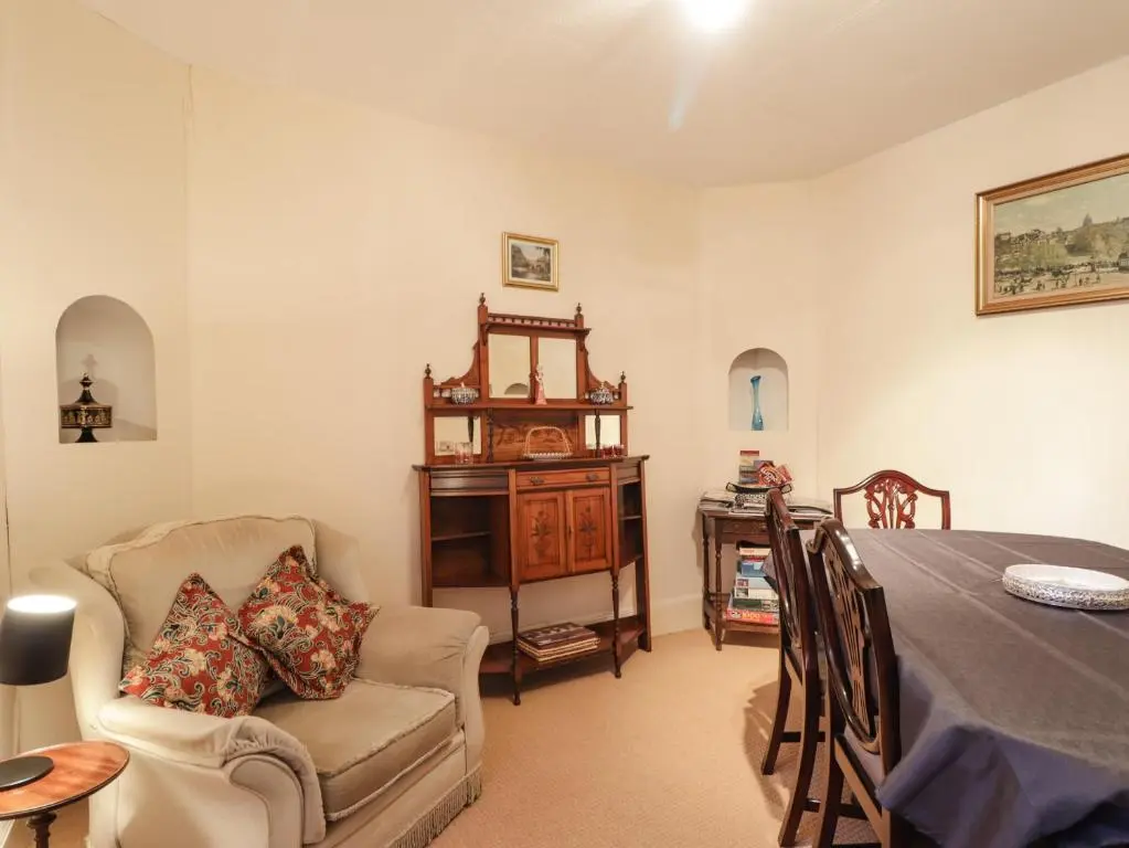 a living room with a table and a chair at Holly Hoose in Findochty