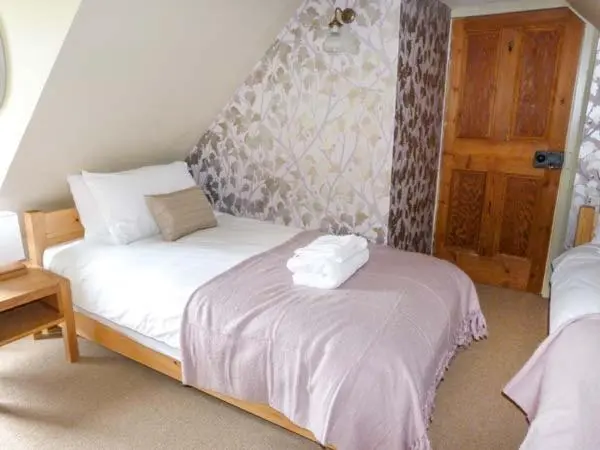 a bedroom with a bed with two towels on it at Easter Duthil Cottage in Duthil