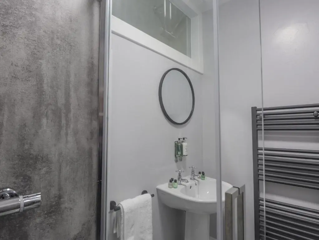 a white bathroom with a sink and a mirror at 1 Seafield Street in Cullen