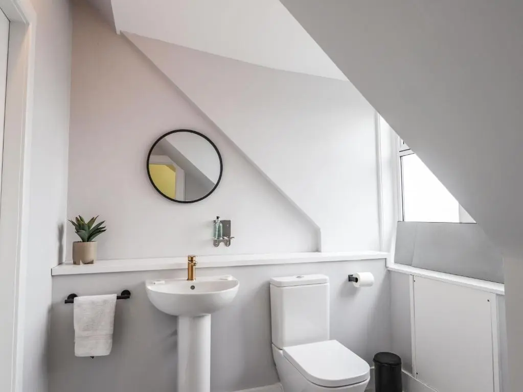 a white bathroom with a sink and a toilet at 1 Seafield Street in Cullen