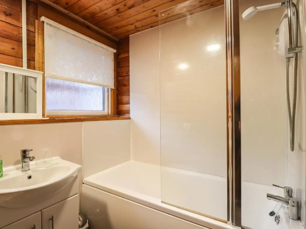 a bathroom with a shower and a sink at Spruce Lodge in Strathpeffer