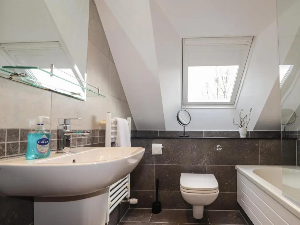 a bathroom with a sink and a toilet and a tub at Little Chestnut in Muir of Ord