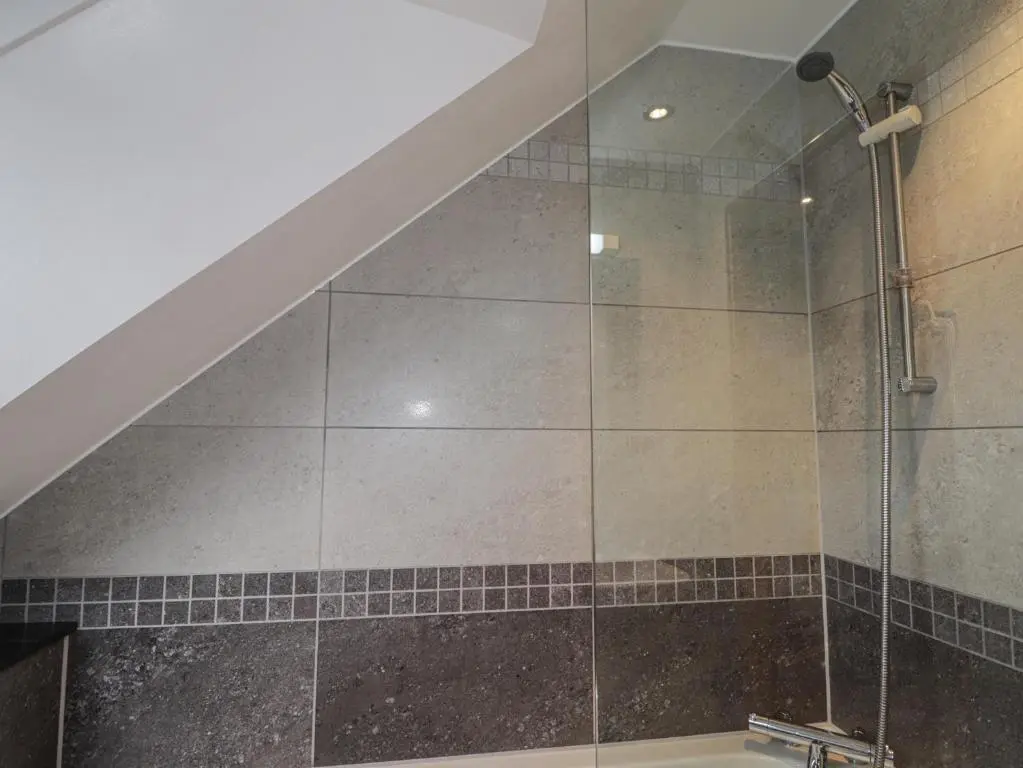 a bathroom with a shower with a glass door at Little Chestnut in Muir of Ord