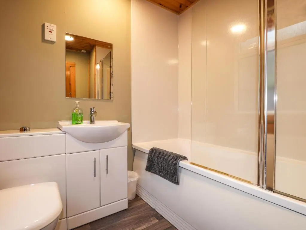 a bathroom with a sink and a shower at Rowan Lodge in Strathpeffer