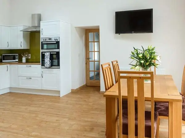 a kitchen with a wooden table and a dining room at The Auld Kirk in Forsinain