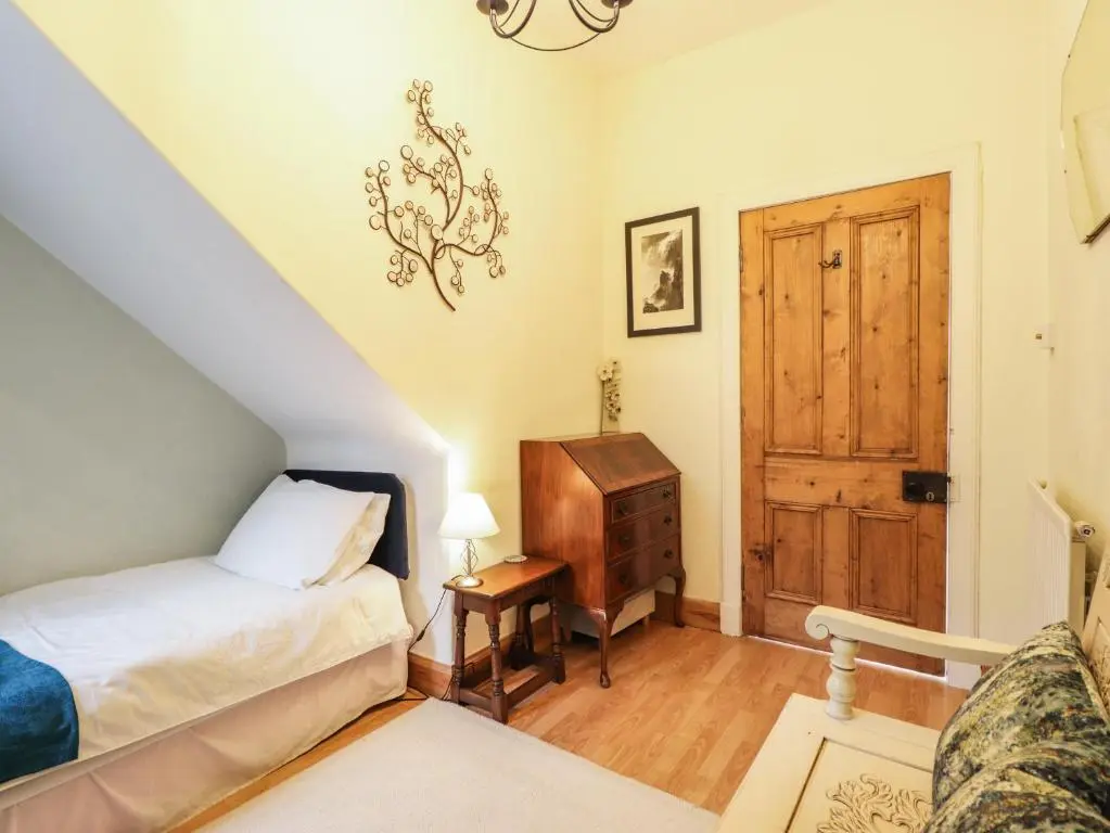 a bedroom with a bed and a wooden door at Aultmore in Kingussie