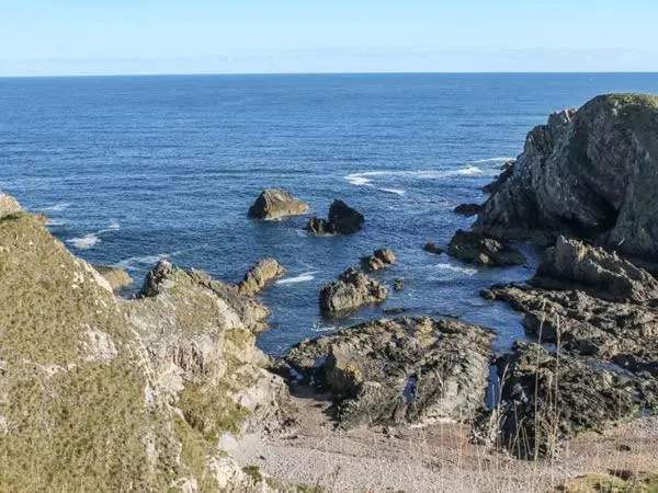 a group of rocks in the water near the ocean at Slater's in Portknockie