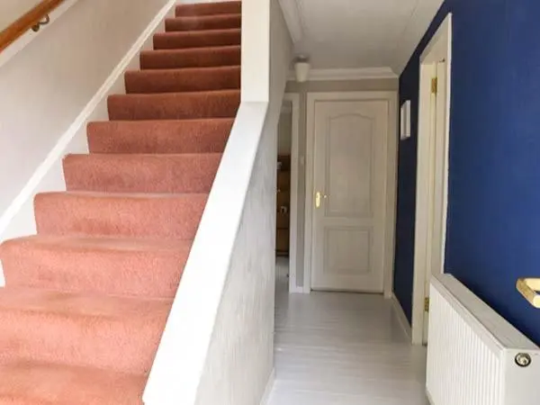 a stairway with pink carpet and blue walls at Cottage Fia in Jamestown