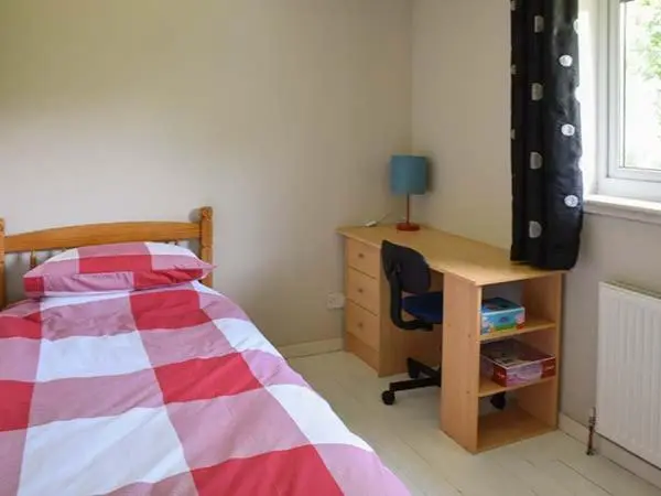 a bedroom with a bed and a desk and a desk at Cottage Fia in Jamestown