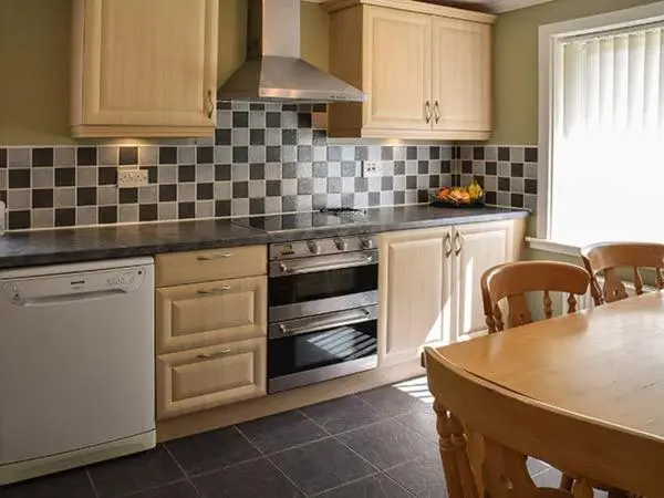 a kitchen with white appliances and a table with chairs at Cottage Fia in Jamestown