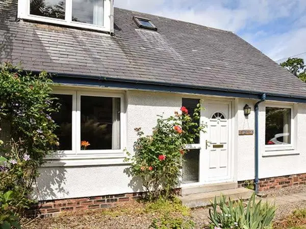 a white house with a white door and flowers at Cottage Fia in Jamestown