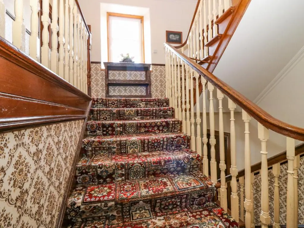 a set of stairs with a rug on them at The West Wing in Skye of Curr