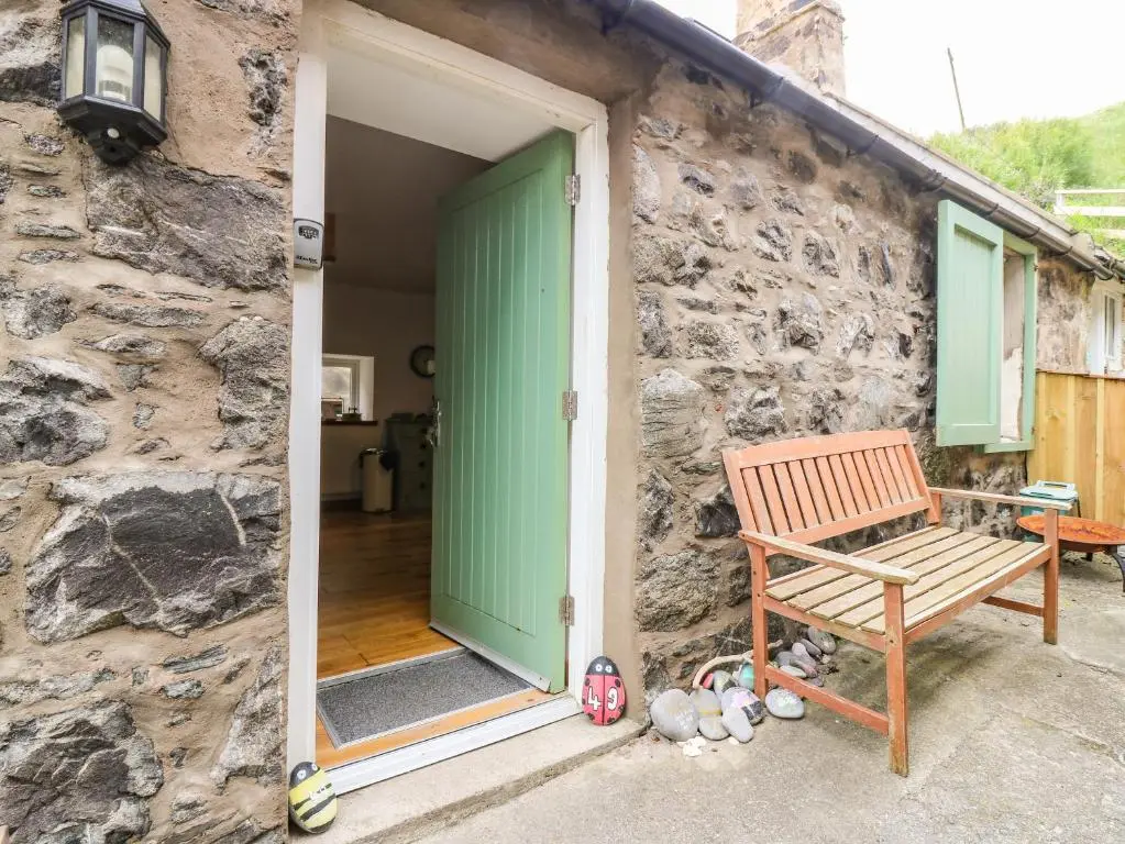 a wooden bench sitting in front of a stone wall at 49 Crovie Village in Gardenstown