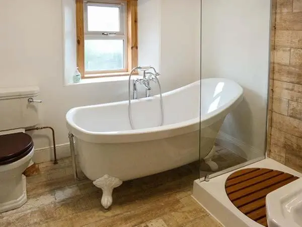 a white bath tub in a bathroom with a toilet at Coorie Doon in Nairn