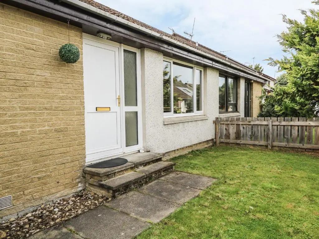 a house with a white door and a yard at 79 Corrour Road in Aviemore