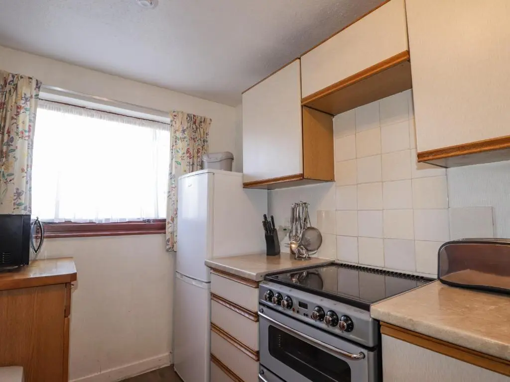 a kitchen with a refrigerator and a stove top oven at Alt na Voir in Tomintoul
