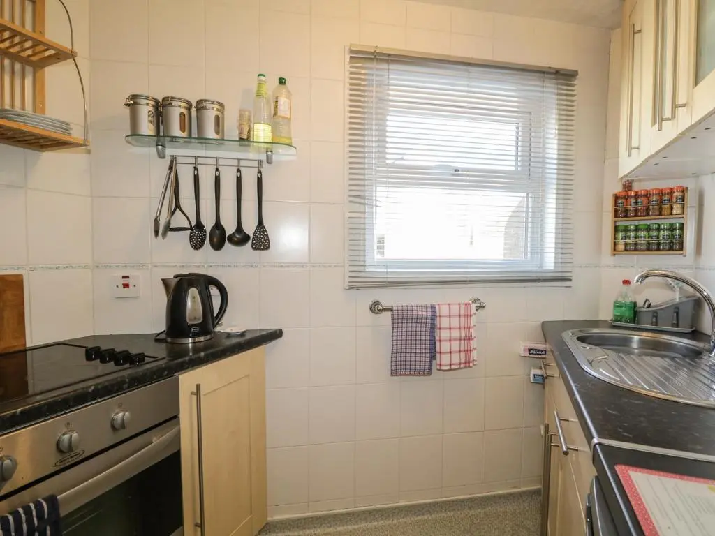 a kitchen with a sink and a stove at Fishermans Rest in Burghead