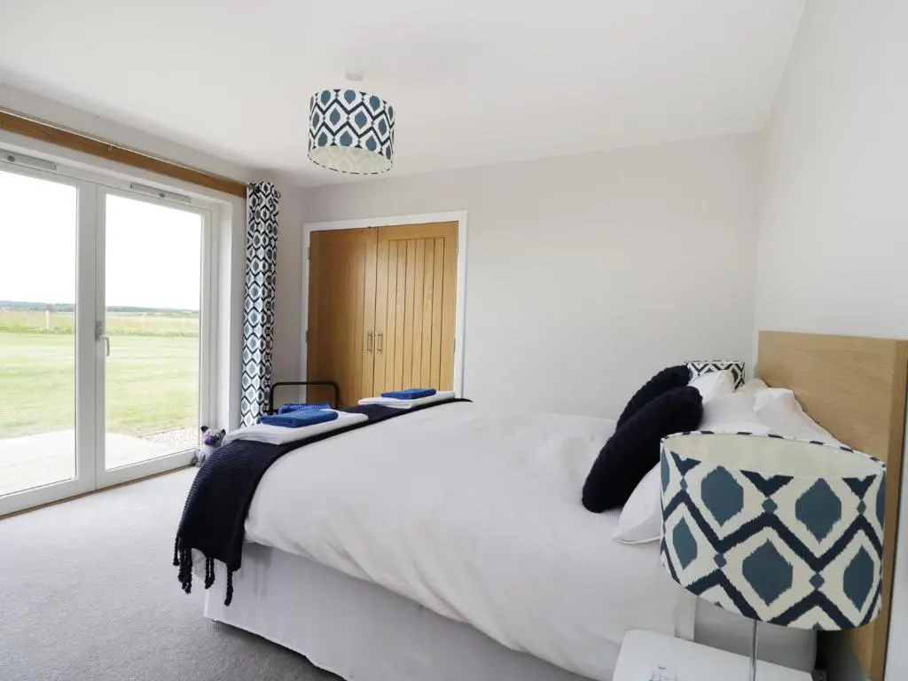 a bedroom with a large bed and a large window at Chance Inn Lodge in Balmedie