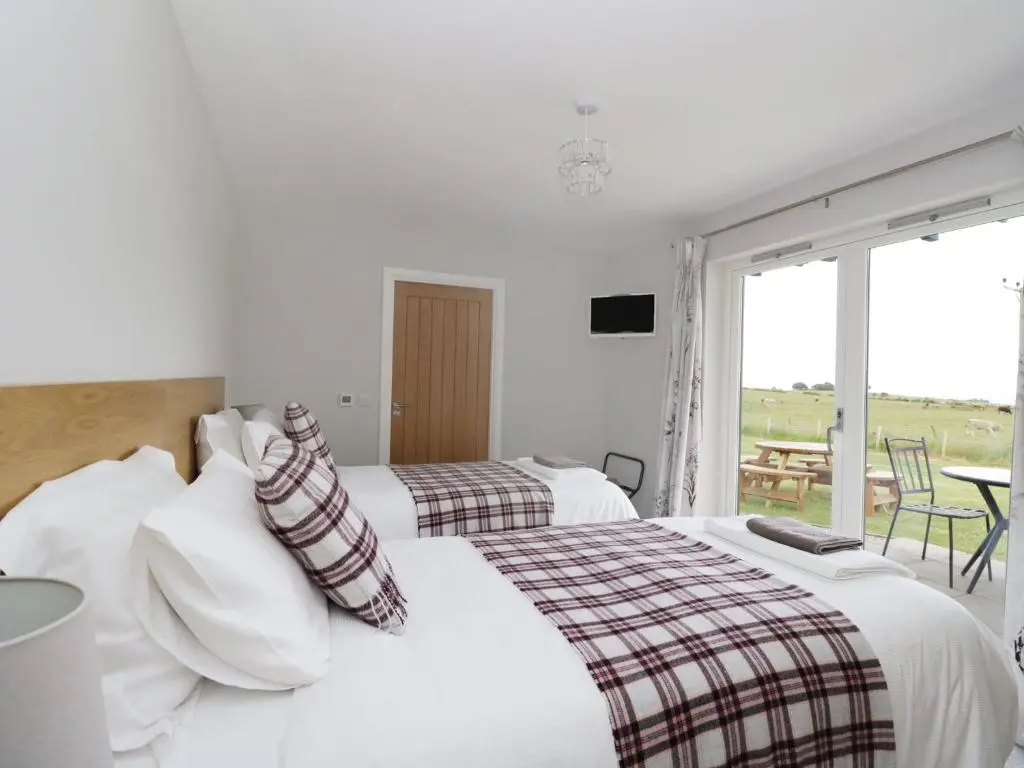 a hotel room with two beds and a patio at Chance Inn Lodge in Balmedie