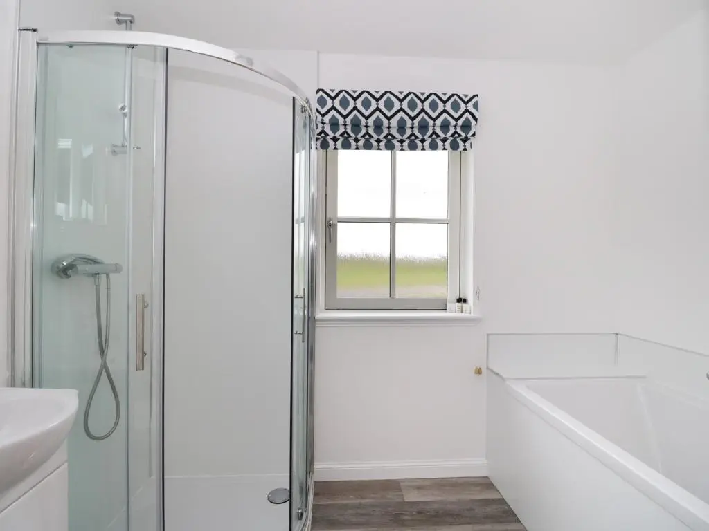 a white bathroom with a shower and a window at Chance Inn Lodge in Balmedie