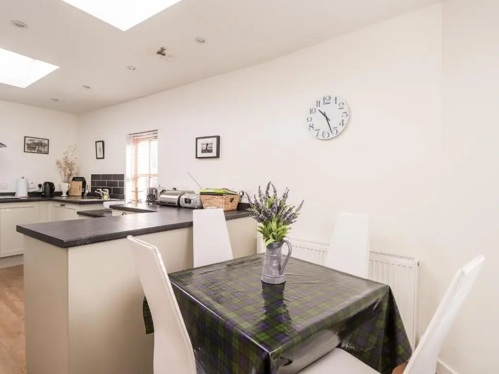 a kitchen and dining room with a table and chairs at 59 Society Street in Nairn