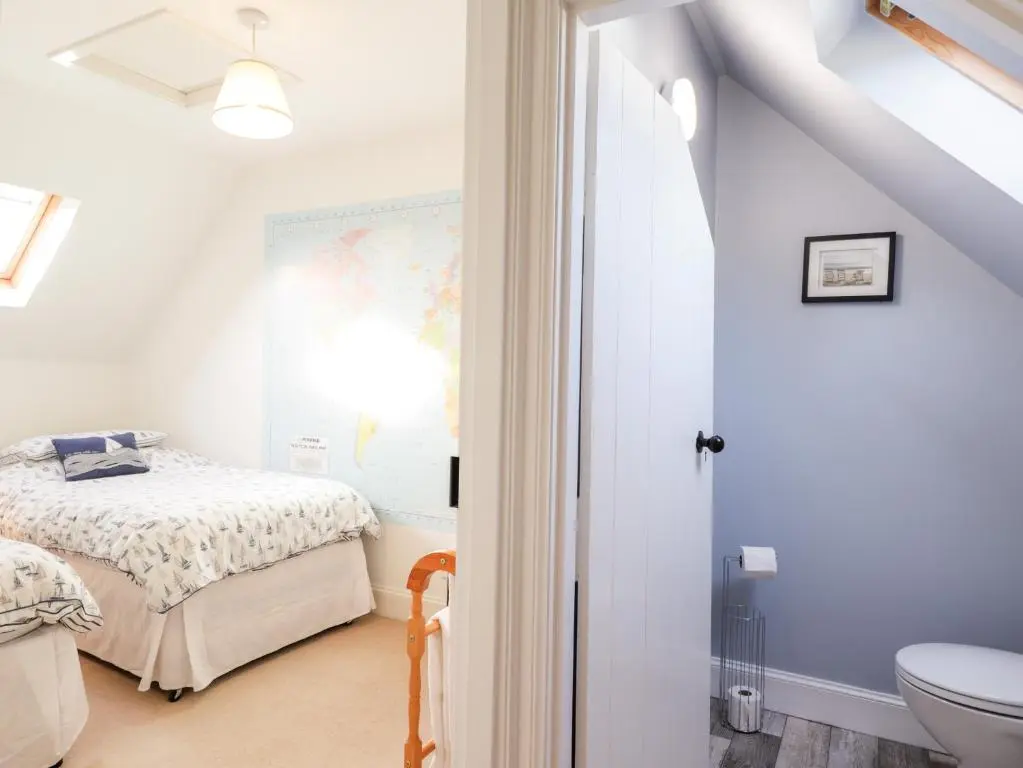 a bathroom with a bed and a toilet in a room at 59 Society Street in Nairn
